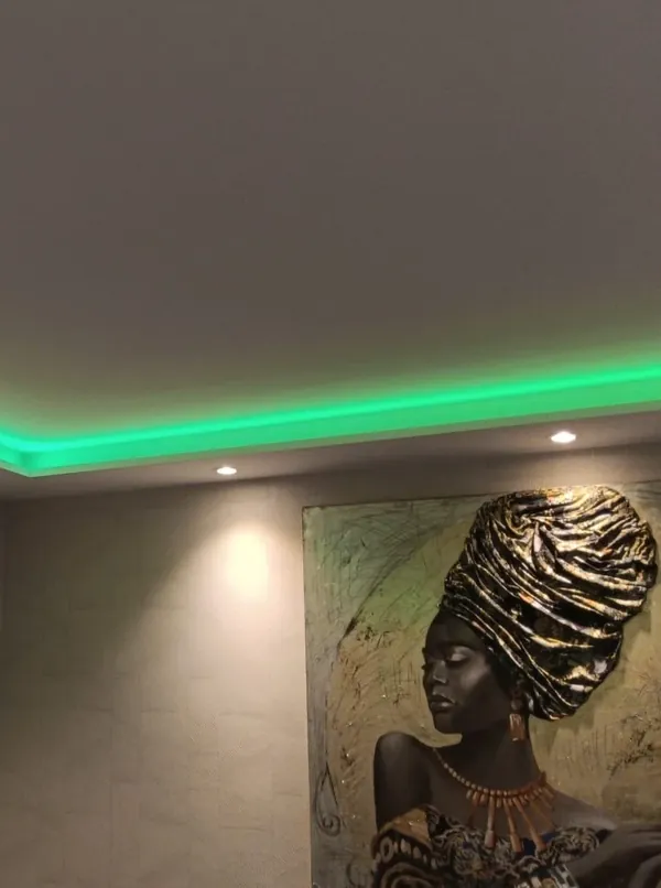Gestaltung einer modernen Wand mit grüner indirekter Deckenbeleuchtung
